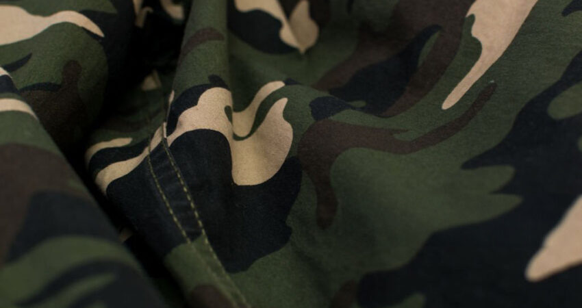 Military camouflage green, black, brown and beige uniform, background, close up